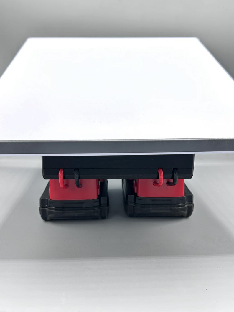 Op de afbeelding: Een zwarte speelgoedtruck met rode accenten en een aanhanger met een vlakke laadbak. De truck is gedetailleerd en gemaakt van plastic.