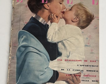 May include: A vintage Elle magazine cover from April 18, 1955, featuring a photograph of an adult and a child embracing. The magazine title is printed in large pink letters at the top, with French text detailing article topics on the right side.