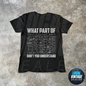 May include: Black t-shirt with white text and mathematical equations. The text reads "WHAT PART OF DON'T YOU UNDERSTAND". The shirt has a crew neck and short sleeves. A Local Vintage Dealer logo is in the bottom right corner.