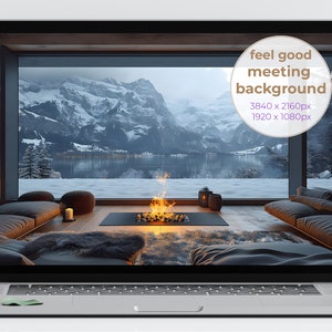 May include: A laptop computer displaying a digital image of a cozy living room with a fireplace and a view of snow-capped mountains and a lake. The text "feel good meeting background" is displayed on the screen.
