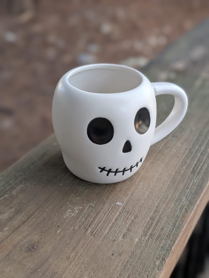 May include: A set of three ceramic mugs with a speckled, matte finish. The mugs are in shades of cream, light gray, and dark gray. Each mug has a simple, minimalist design and a rounded handle.