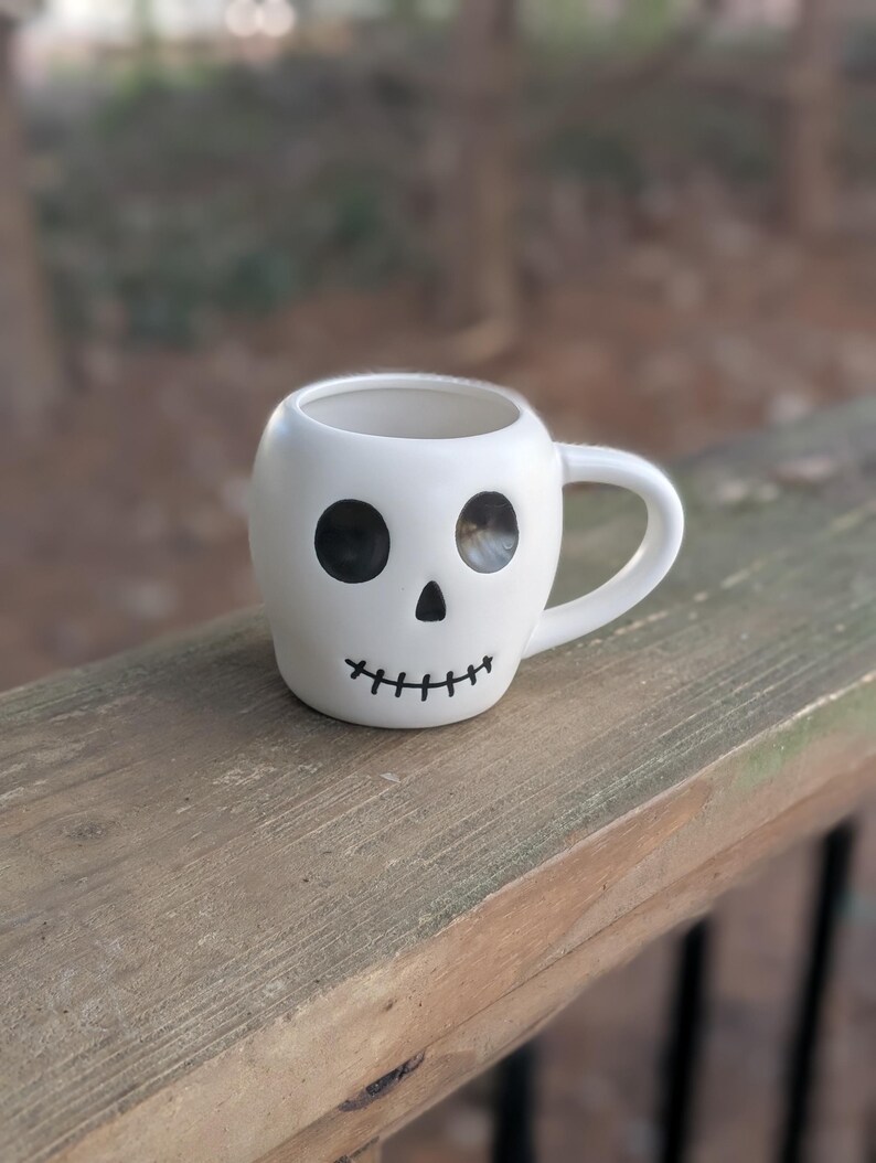 May include: A set of three ceramic mugs with a speckled, matte finish. The mugs are in shades of cream, light gray, and dark gray. Each mug has a simple, modern design and a rounded handle.