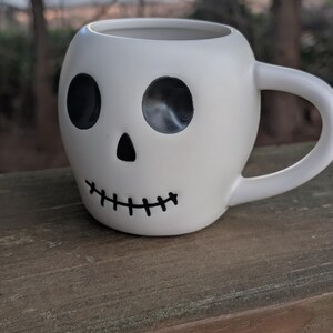 May include: A set of three ceramic mugs with a speckled, matte finish. The mugs are in shades of cream, light gray, and dark gray. Each mug has a simple, minimalist design, perfect for coffee or tea.