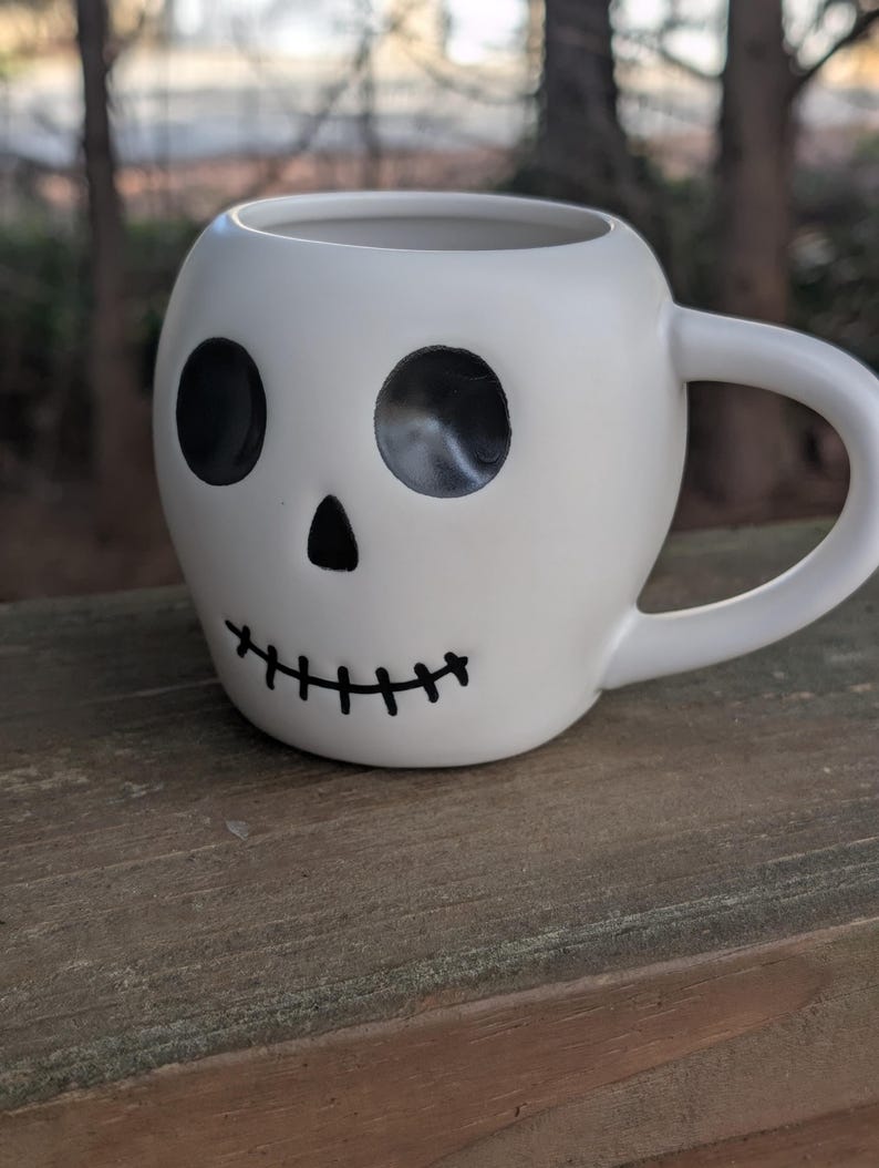 May include: A set of three ceramic mugs with a speckled, matte finish. The mugs are in shades of cream, light gray, and dark gray. Each mug has a simple, minimalist design, perfect for coffee or tea.