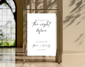 May include: White welcome sign with black text that reads "Welcome to the night before celebrating River + Everly 08.07.2023 | Boston". The sign is on a gold stand.
