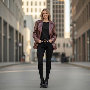 Peut inclure: Un blazer bronze métallisé à la texture façon peau de serpent, porté sur un haut noir uni et un jean noir ajusté. La tenue comprend une ceinture noire avec une boucle double G dorée et des bottines en cuir noir à talons carrés.