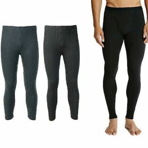 Peut inclure: Trois paires de sous-vêtements thermiques. Deux paires sont gris foncé et une paire est noire. Les sous-vêtements ont une texture côtelée et une coupe ajustée. La paire noire est portée par une personne.