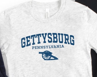 May include: A heather grey t-shirt with a blue vintage-style graphic that reads "Gettysburg, Pennsylvania" with a cannon illustration.