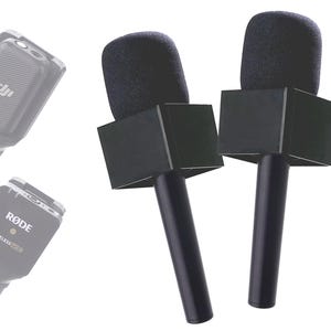 May include: Two black wireless microphones with foam windshields and a black square-shaped mount. The microphones are on a white background.