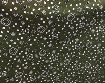 May include: Dark green fabric featuring a white paisley design. The pattern includes paisley shapes, floral motifs, and geometric elements, forming a repeating design across the material.