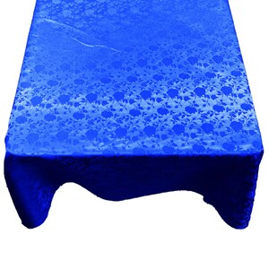 May include: A royal blue tablecloth with a white floral pattern. The tablecloth is made of a textured fabric and has a slight sheen.