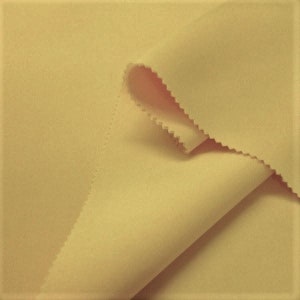 May include: A close-up of a pale yellow fabric. The fabric is smooth and has a subtle sheen. It is folded in half, with the edges of the fold visible.