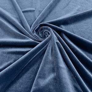 Könnte beinhalten: Nahaufnahme eines weichen, blauen Samtstoffes mit einem wirbelnden Muster. Der Stoff ist glatt und luxuriös, mit einem dezenten Glanz.