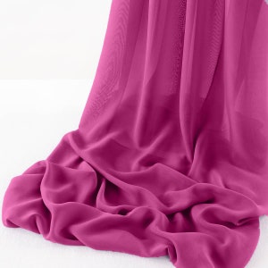 May include: A vibrant pink sheer fabric draped over a white surface. The fabric is soft and flowing, creating a delicate and elegant look.