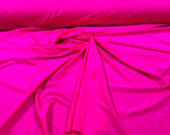 May include: A bright pink fabric with a smooth, silky texture. The fabric is folded and draped, showcasing its soft and flowing nature.