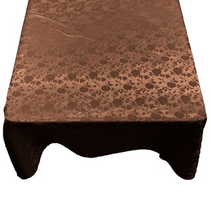 May include: A brown tablecloth with a floral pattern. The tablecloth is made of a soft, silky material and has a subtle sheen.