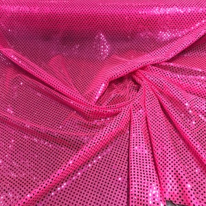 Puede incluir: Tela rosa con un patrón de pequeños puntos brillantes.