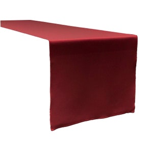 May include: A burgundy table runner made of satin fabric. The runner is approximately 14 inches wide and 72 inches long.