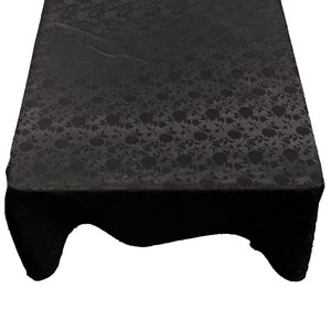 May include: Black tablecloth with a floral pattern. The tablecloth is made of a soft, silky fabric and has a subtle sheen.