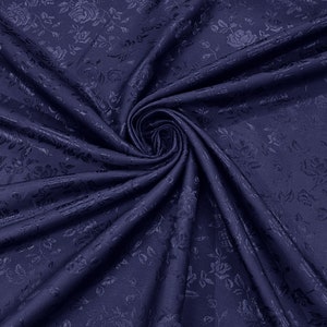 May include: A close-up of a dark blue fabric with a floral pattern. The fabric is soft and has a subtle sheen.