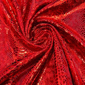 May include: Red fabric with a snakeskin pattern. The fabric is shiny and has a metallic sheen.