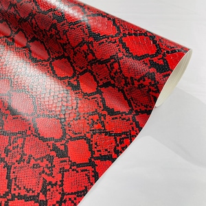 May include: Red and black snakeskin patterned vinyl sheet. The vinyl has a glossy finish.