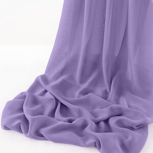 May include: A soft, flowing piece of lavender-coloured fabric draped over a white surface. The fabric is sheer and has a delicate texture.