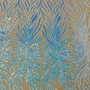 May include: Blue and white iridescent sequin fabric with a flame-like pattern. The sequins are sewn onto a mesh backing.