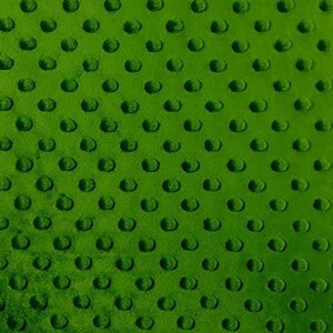 Op de afbeelding: Close-up van een groene stof met een textuurpatroon van gelijkmatig verdeelde, verhoogde cirkels. De stof heeft een zacht, pluche uiterlijk en de cirkels creëren een subtiel, herhalend ontwerp. De kleur is een levendig, medium groen.