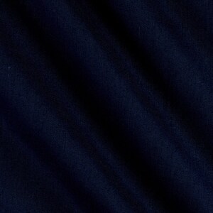 May include: A close-up of a dark blue fabric with a textured surface. The fabric is folded and has a soft, smooth feel.