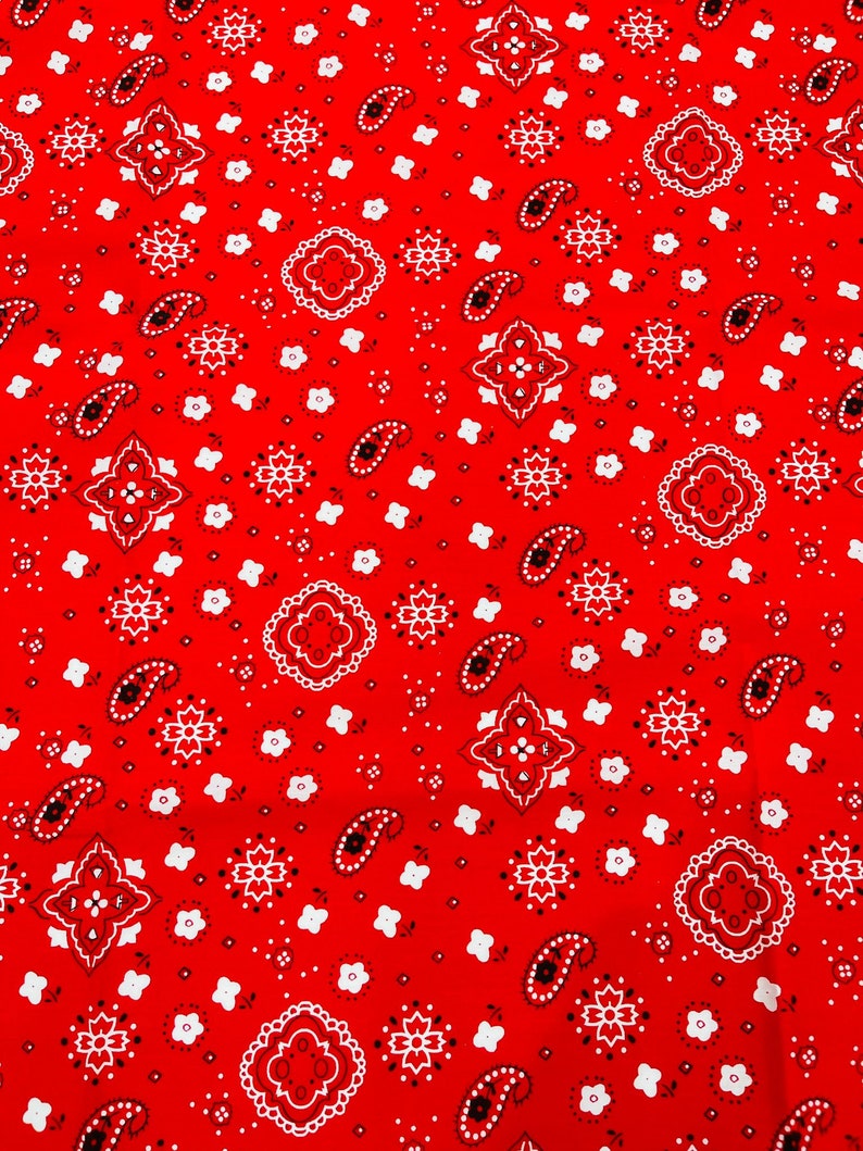 K&ouml;nnte beinhalten: Roter Bandana-Stoff mit einem wei&szlig;en Paisley-Muster. Der Stoff zeigt ein sich wiederholendes Muster aus Paisley-Formen, kleinen Blumen und Rauten.