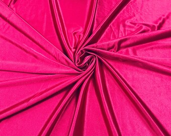 May include: A close-up of a vibrant pink fabric with a smooth, silky texture. The fabric is draped and folded, creating a swirling pattern.