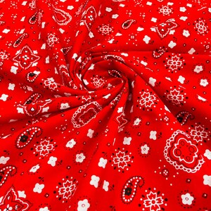 K&ouml;nnte beinhalten: Roter Stoff mit einem wei&szlig;en Bandana-Druck. Der Stoff ist gefaltet und zeigt das Muster.