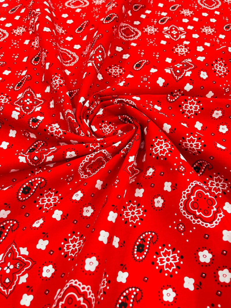 K&ouml;nnte beinhalten: Roter Stoff mit einem wei&szlig;en Bandana-Druck. Der Stoff ist gefaltet und zeigt das Muster.