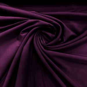 May include: A deep purple fabric with soft, flowing folds. The fabric is smooth and has a luxurious feel.