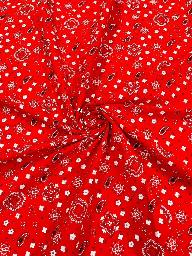 K&ouml;nnte beinhalten: Roter Stoff mit einem wei&szlig;en Paisley-Muster. Der Stoff ist spiralf&ouml;rmig gefaltet.