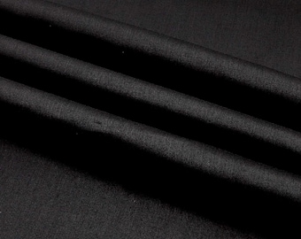 Può includere: Tessuto nero con una texture liscia e setosa. Il tessuto è piegato in modo da creare linee morbide e fluide.