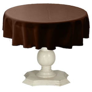 May include: A brown round tablecloth draped over a white pedestal table with a round top and a base with a scalloped edge.