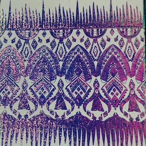 May include: Purple and pink iridescent sequins create a geometric pattern on a white fabric. The design features a repeating pattern of triangles and diamonds.