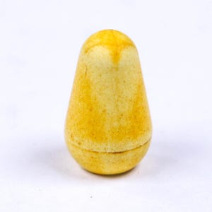 May include: A yellow, pear-shaped object with a slightly textured surface. The top portion is a lighter shade of yellow, and the bottom has a circular indentation. The object is set against a white background.