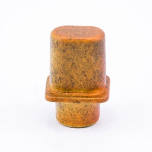 May include: A ceramic knob with a square base and a rounded top. The knob is a mottled yellow and brown color.