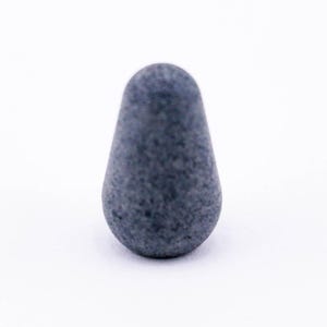 May include: A small, gray, pear-shaped ceramic knob.