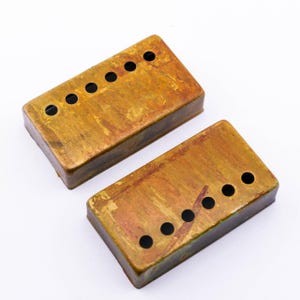 Può includere: Due coperture per pickup di chitarra in metallo color oro con sei fori ciascuna. Le coperture hanno un aspetto usurato e invecchiato con una finitura screziata multicolore.