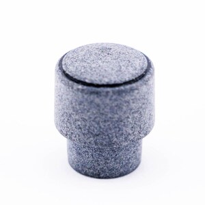 May include: A gray, cylindrical bottle stopper with a textured surface. The stopper has a rounded top and a slightly wider base, suitable for sealing bottles. The design is simple and modern, with a focus on the material's natural appearance.