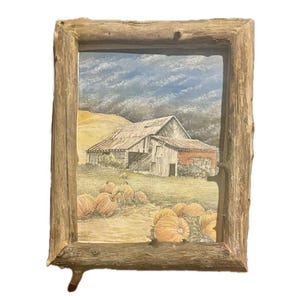 Pode incluir: Uma pintura a aquarela emoldurada que retrata um celeiro rústico com um campo de abóboras em primeiro plano. O céu está cinzento e tempestuoso com nuvens brancas. O celeiro é pintado em tons de cinza e marrom, com um telhado vermelho. As abóboras são laranja e amarelas.