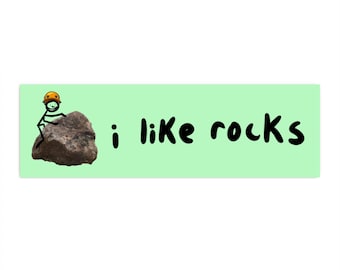 May include: A stick figure wearing a yellow helmet climbs a gray rock. The text "i like rocks" is written in black on a light green background.