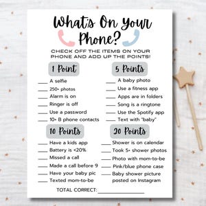 May include: A white paper game sheet with the text "What's On Your Phone?" in black script. The game includes a checklist of phone-related items, with point values assigned to each. The sheet is designed for a baby shower.