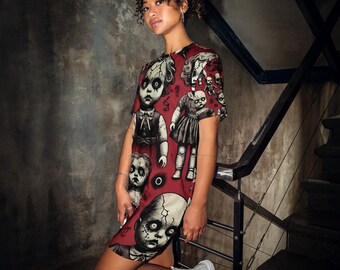 Può includere: Un vestito a t-shirt rosso con una stampa di diverse bambole con volti inquietanti. Il vestito ha maniche corte e un collo rotondo.