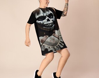 Può includere: Abito t-shirt nero con stampa grafica di una bambola inquietante con il viso screpolato e un grembiule insanguinato.