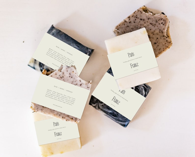 May include: Four bars of handmade soap with labels that say "Paris, France" and "Rose | Smoke | Cypress". The soap is a mix of white and black with a speckled appearance.